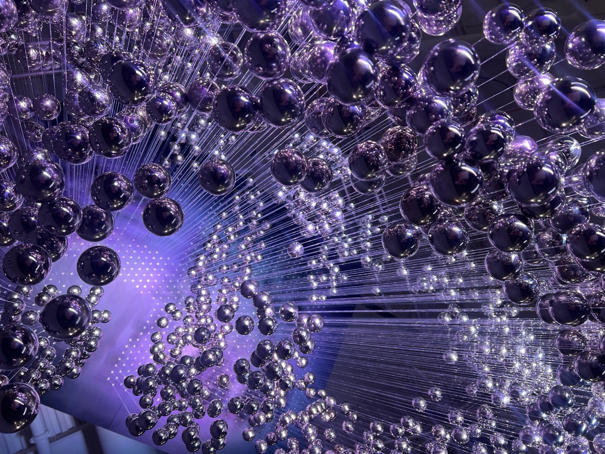 Hundreds of polished stainless steel float balls suspended in a large-scale art installation
