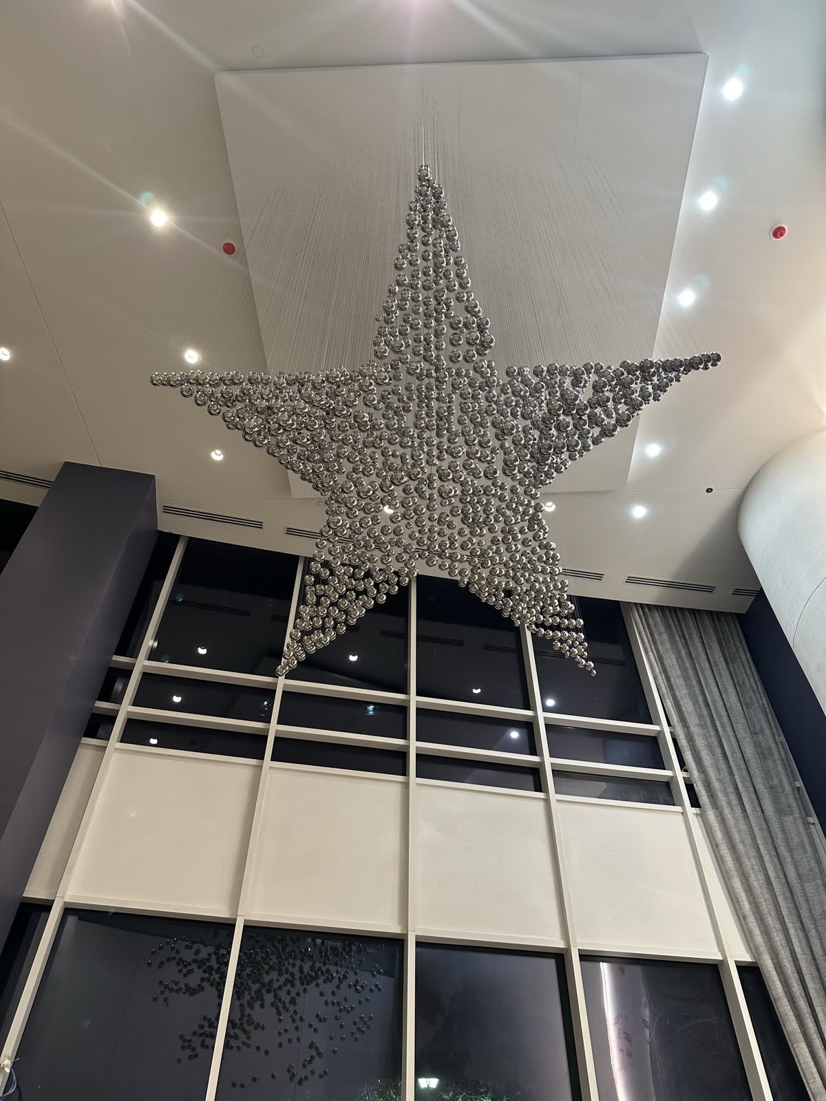 Star sculpture built from hundreds of polished stainless steel float balls in a hotel lobby