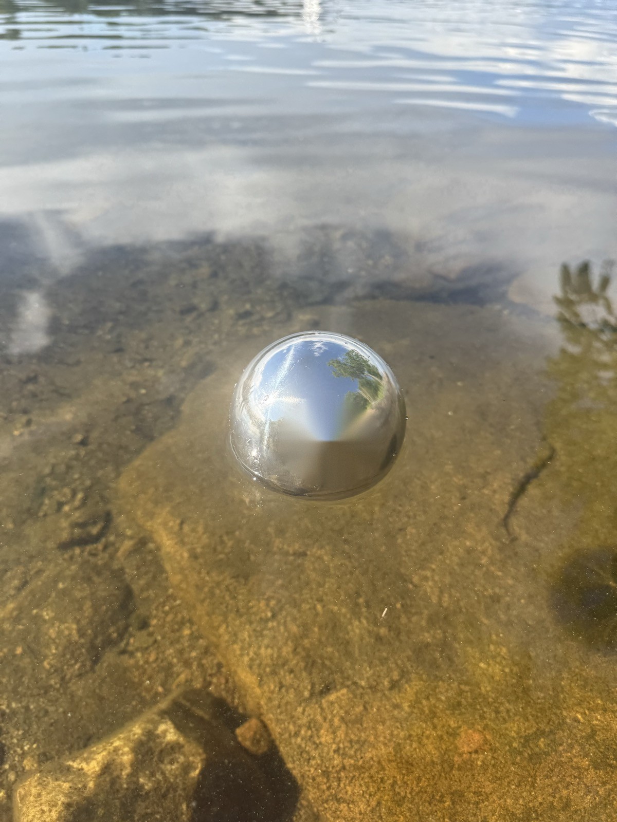 Polished stainless steel float ball floating on open water